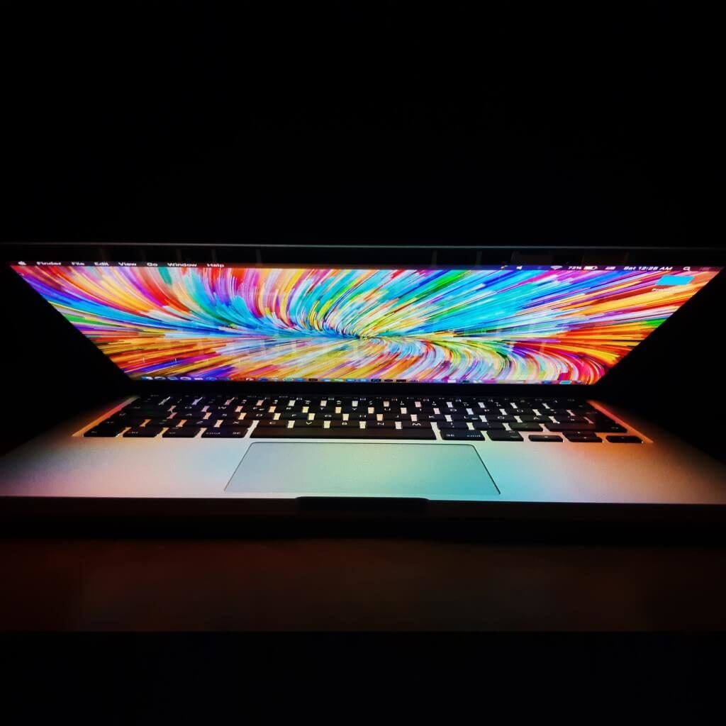 Computer with rainbow colour swirl image on screen